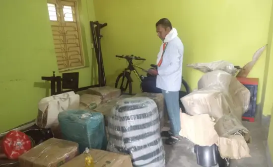 Professional movers packing household items in cardboard boxes